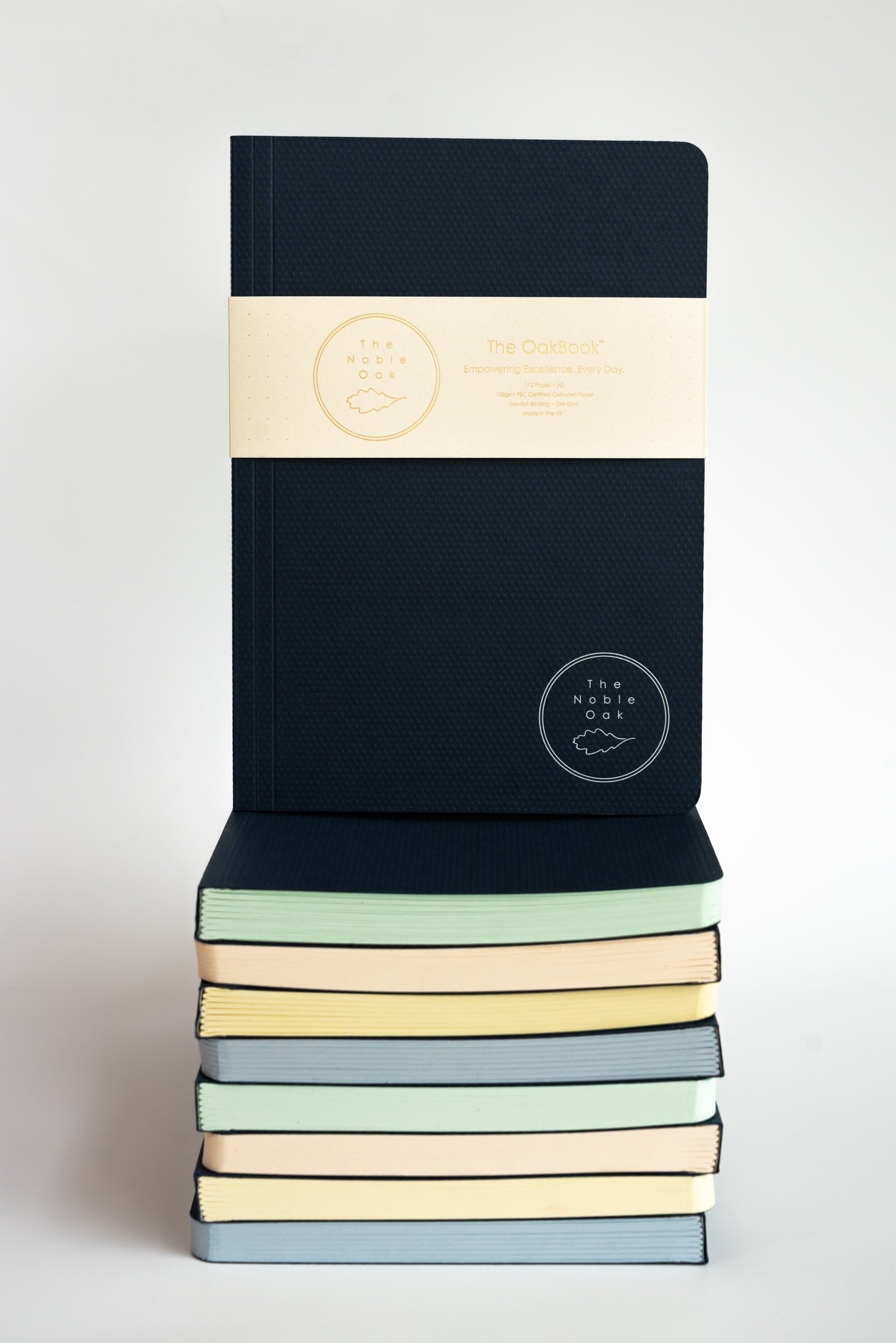 Stack of notebooks with pastel covers on a white background