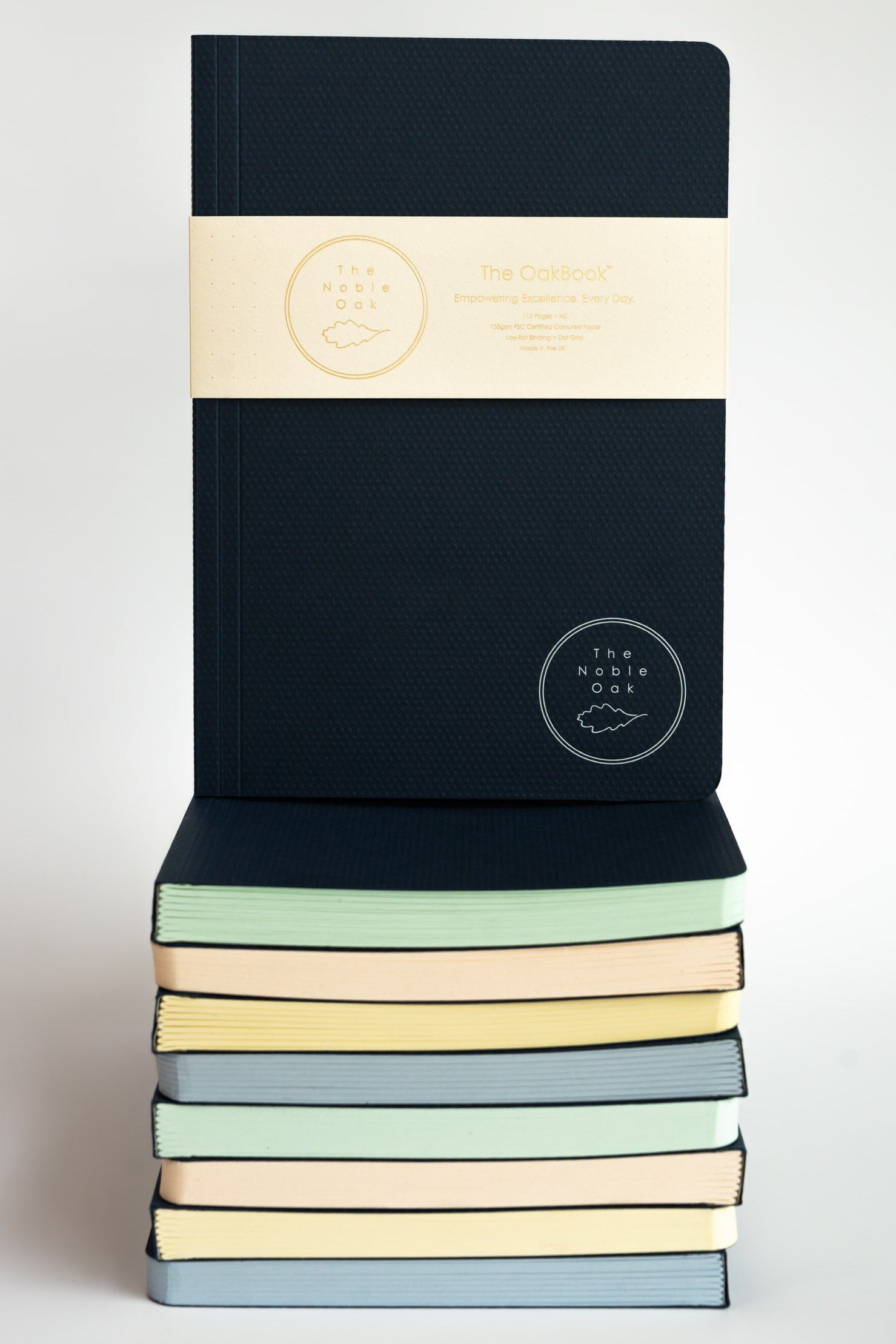 Stack of notebooks with pastel covers on a white background